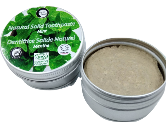 Natural solid toothpaste in a metal tin with green label on a white background