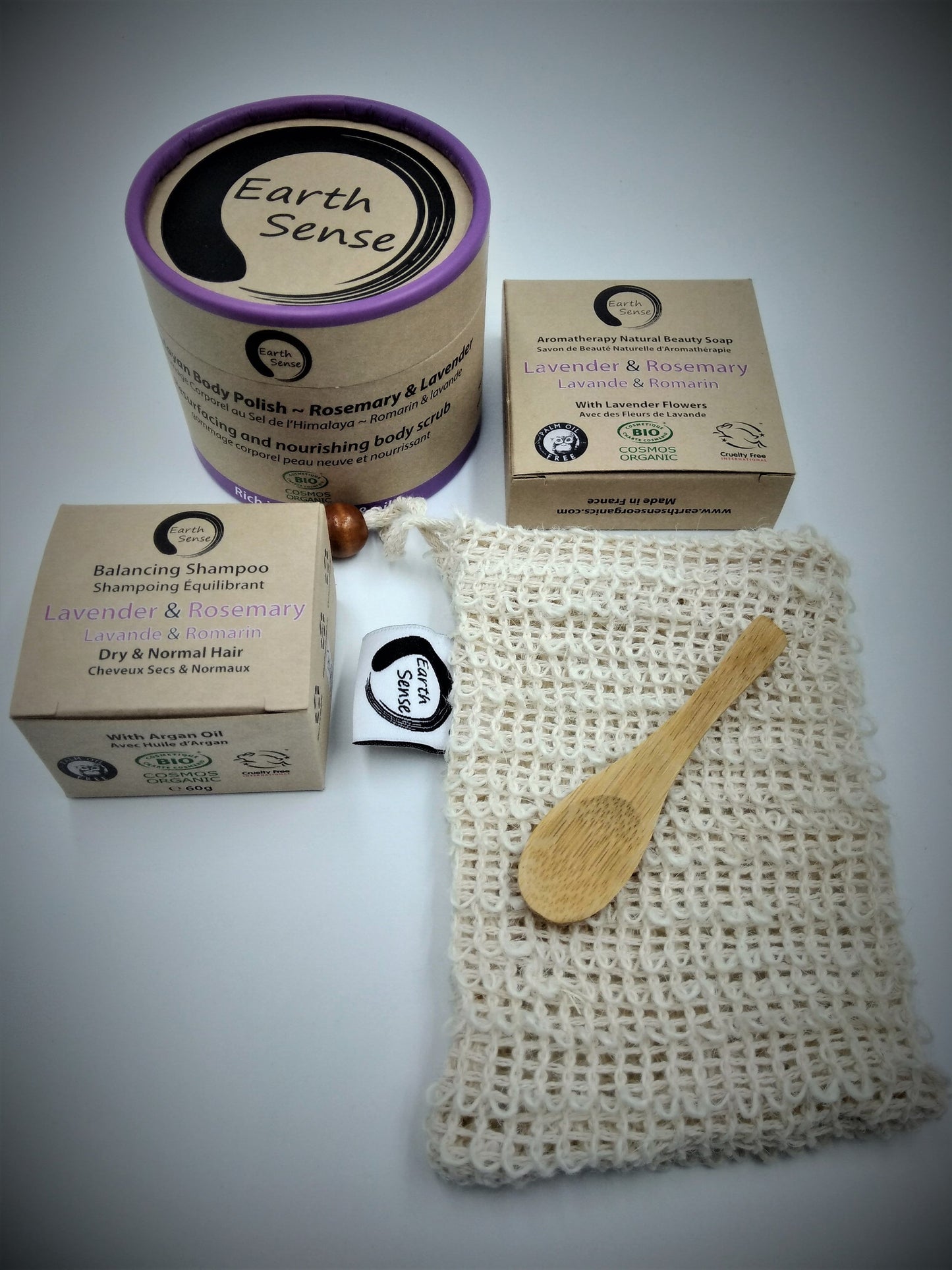Earth Sense natural products including a can, boxes, a bag with a wooden spoon on a gray background