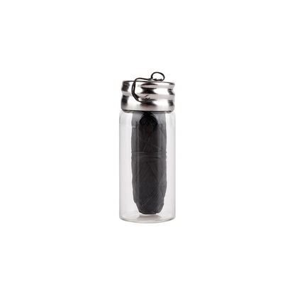 Clear glass container with a black feather inside on a white background