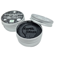 Black candle in a white container with a lid on a white background