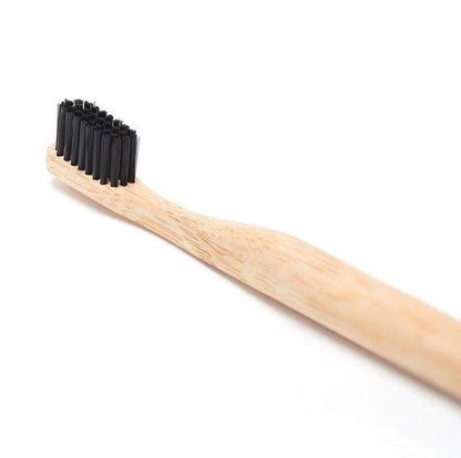 Bamboo toothbrush with black bristles on a white background
